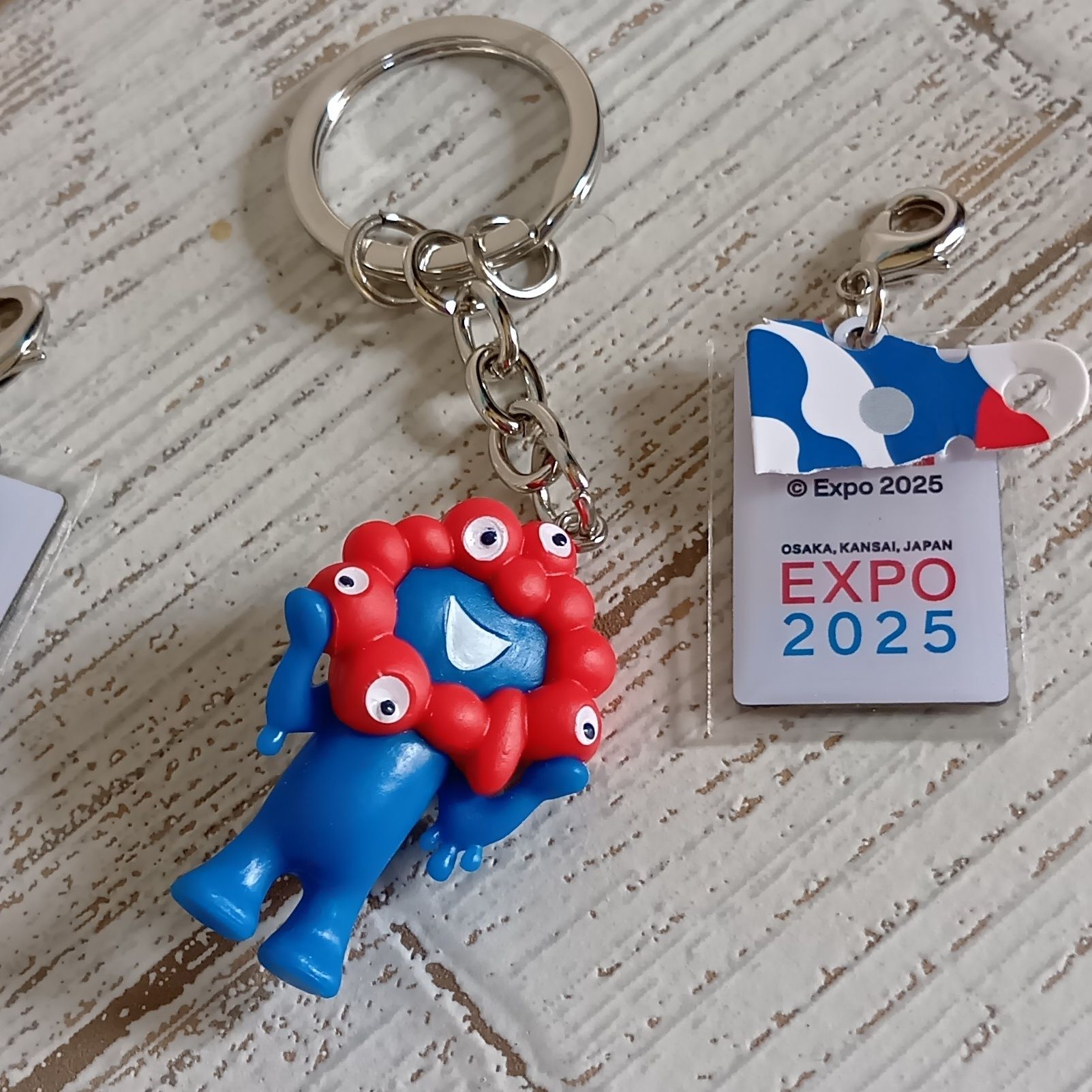 株式会社モノコム 万博公式グッズ：2025アニバーサリーキーホルダーの