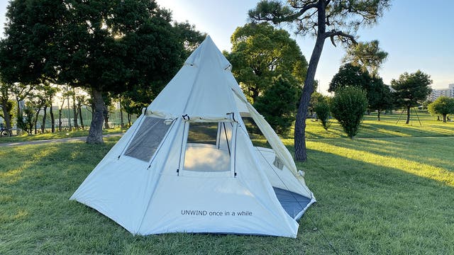 広い窓からは光と風が入る。解放感を求めたティピーテントとタープで緑