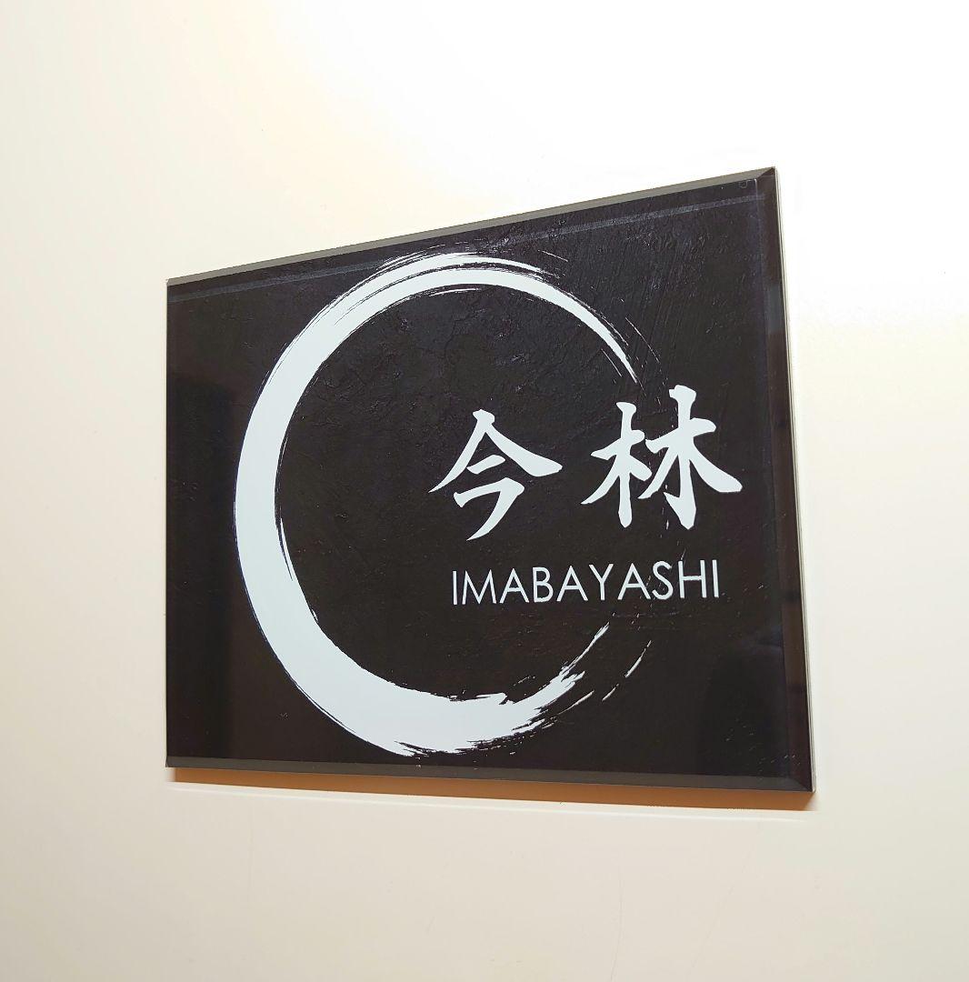 黒しっくい壁背景・白文字＋筆丸イラストのアクリル表札＊45度斜め